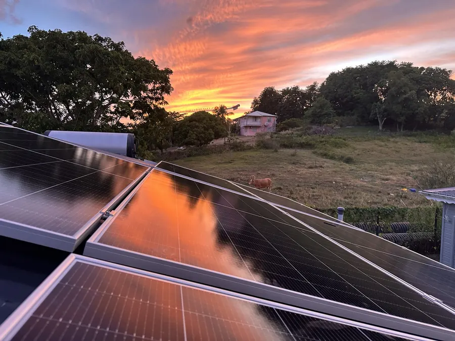 Installation solaire Petit-Bourg Guadeloupe 12 kWc — panneaux solaires en toiture au coucher du soleil